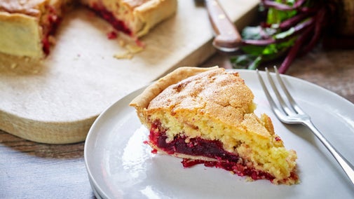 A slice of beetroot, bacon and cheese cake on a plate